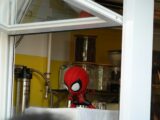 a spider - man doll sitting in a kitchen window