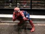 a man dressed as a spiderman crouching down