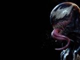 Venom with his tongue out against black background
