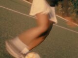 A person kicking a soccer ball on a field