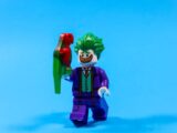 Lego joker holding a green and red parrot
