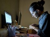 A woman sitting at a desk working on a computer