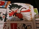 Young goku in action with a red staff.