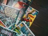 a pile of comics sitting on top of a wooden table