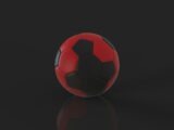 A red and black soccer ball sits still.