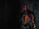 Dark figure with glowing orange core and red hair