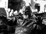 a black and white photo of a man in a batman costume