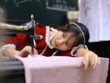 a young girl sitting at a table with a sewing machine