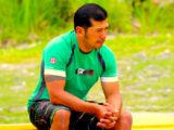 Man in green shirt looks thoughtful.