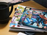 Stack of comic books next to a mug of coffee.