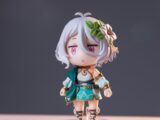 Close-up of an anime figurine featuring white hair and a decorative flower, on a neutral background.