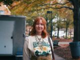 A woman standing next to a trash can