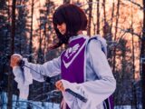 a woman in a purple and white outfit holding a pair of skis