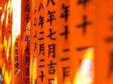 a row of orange signs with asian writing on them