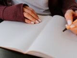 person writing on white paper