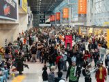 a large group of people walking through an airport