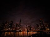 a city skyline at night with lights reflecting in the water