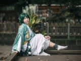 woman in white and green robe sitting on brown wooden bench