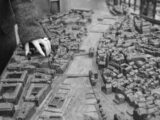 Hand touching a detailed architectural model of a city