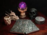 a wooden table topped with a book and a skull