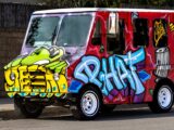 A vibrant van adorned with graffiti art parked on a city street, showcasing urban creativity.
