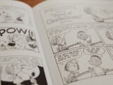 Peanuts comic strip open on a book.