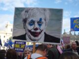 person holding man wearing clown face art