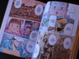 Open manga book with colorful illustrations.