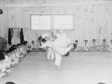 a group of young evacuees receiving instruction in Jiu Jitsui, or Judo wrestling at Portland (Oregon) Assembly Center, while the rest of class look on